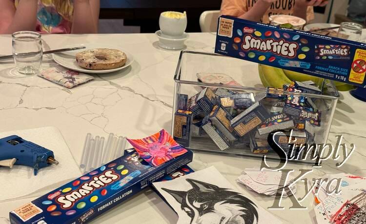 As the kids ate breakfast one morning I started hot gluing the Smarties to the cards. 