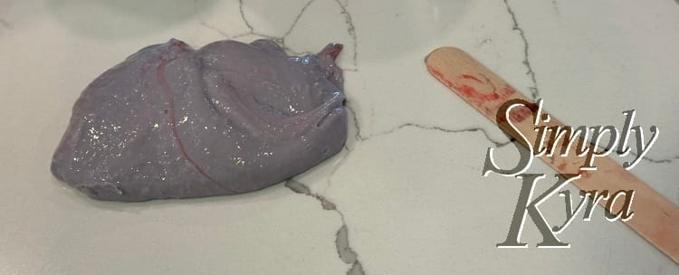 Pile of purple slime next to a red dappled wooden stick.