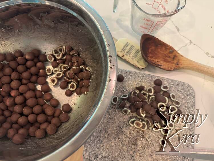 Now we're closet to the bowl with cutting board next to it. Some of the spheres are cut in half showing brown inside, lined with whilteness, and a thin brown outside.