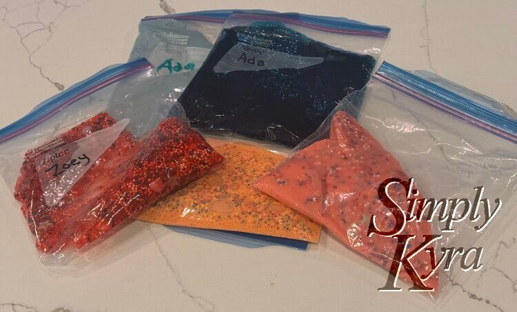 Several bags of flattened colorful and bedazzled slime.