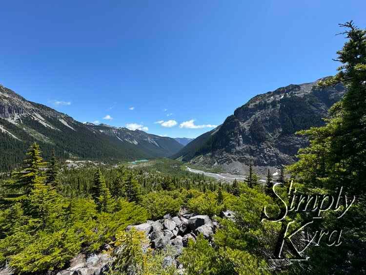 Blue sky, mountains, trees, and rocks. 