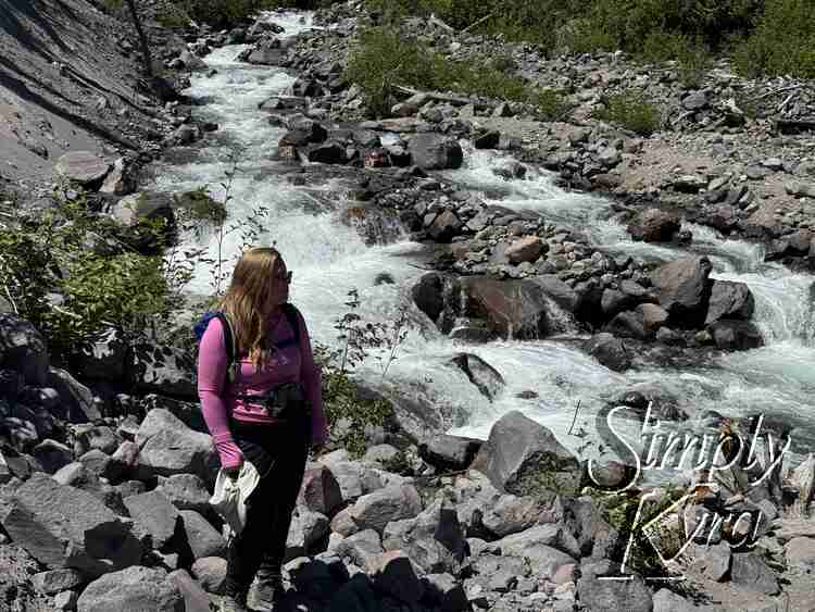 Me standing looking to the distance by raging river. 