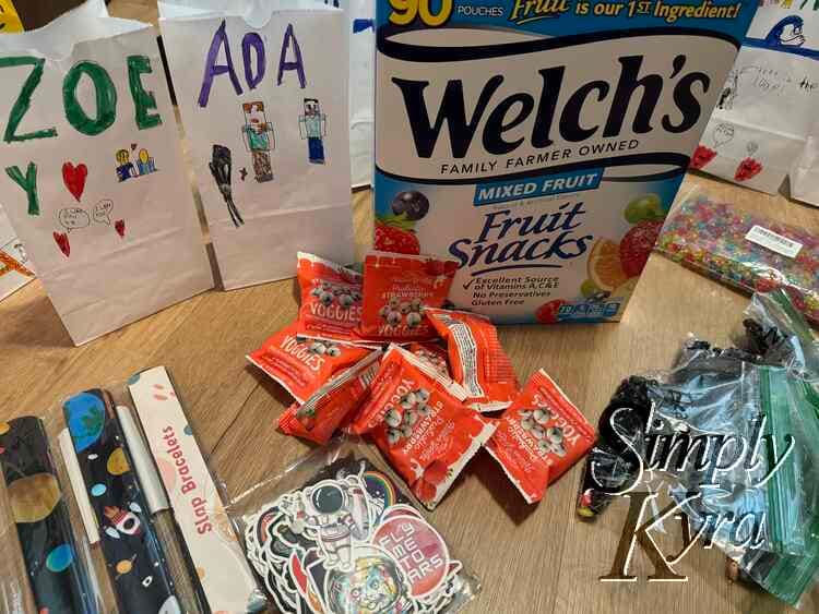 Image shows some decorated bags, fruit snack box, yogurt treats, slap bracelets, activity bags, and sealed stickers all ready to go.