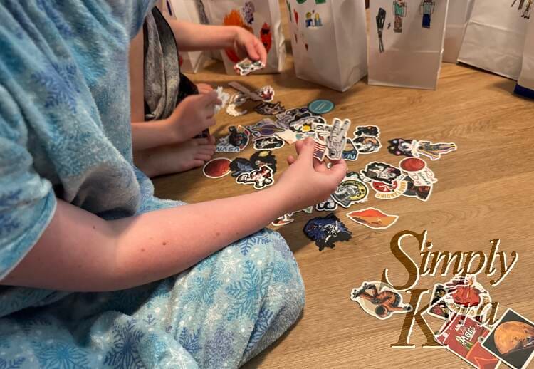 Image shows the kids going through the stickers in front of the bags.