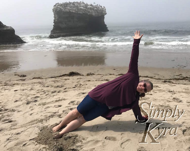 Image shows me attempting a side plank at a beach in California. 